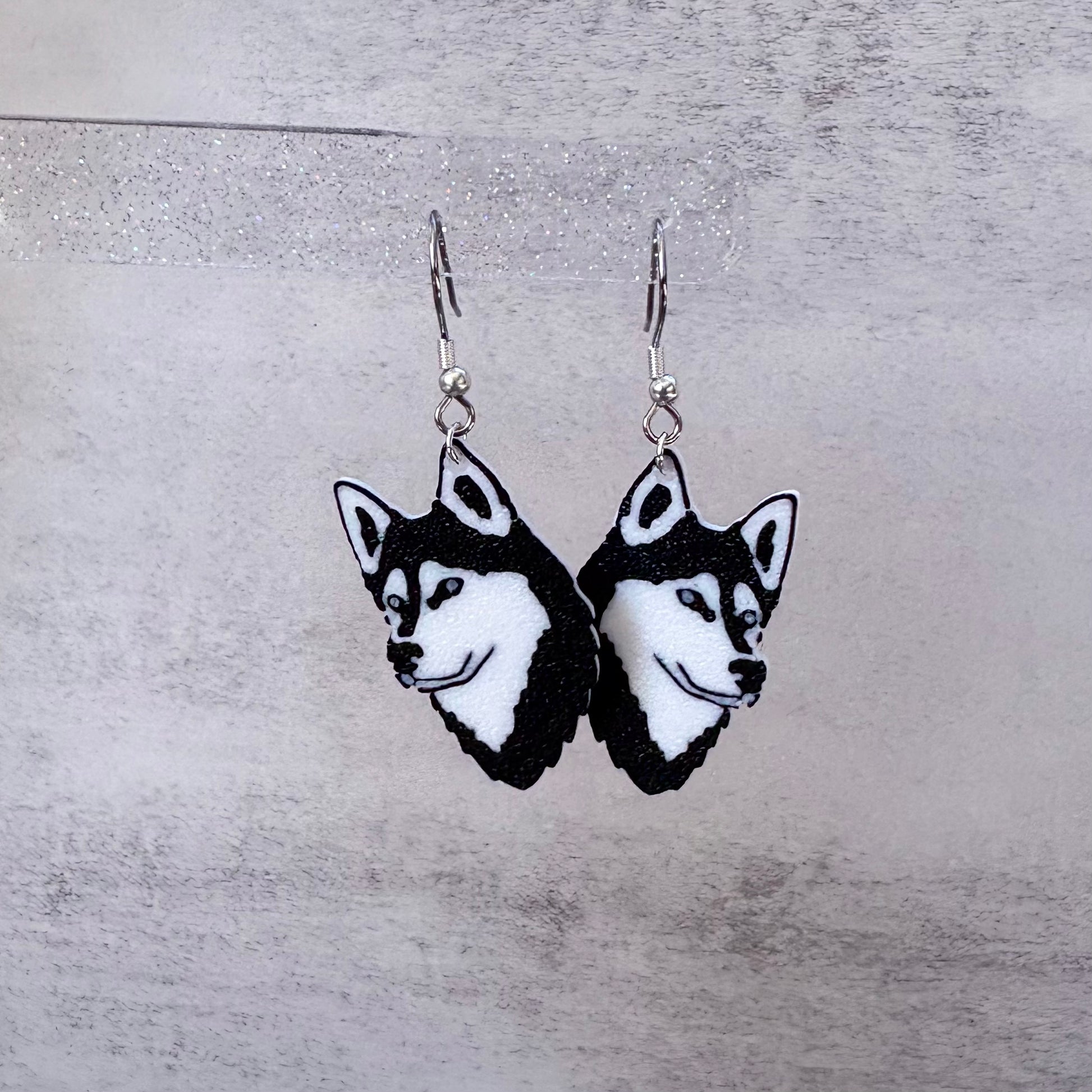 Siberian Husky dog head earrings on a gray background