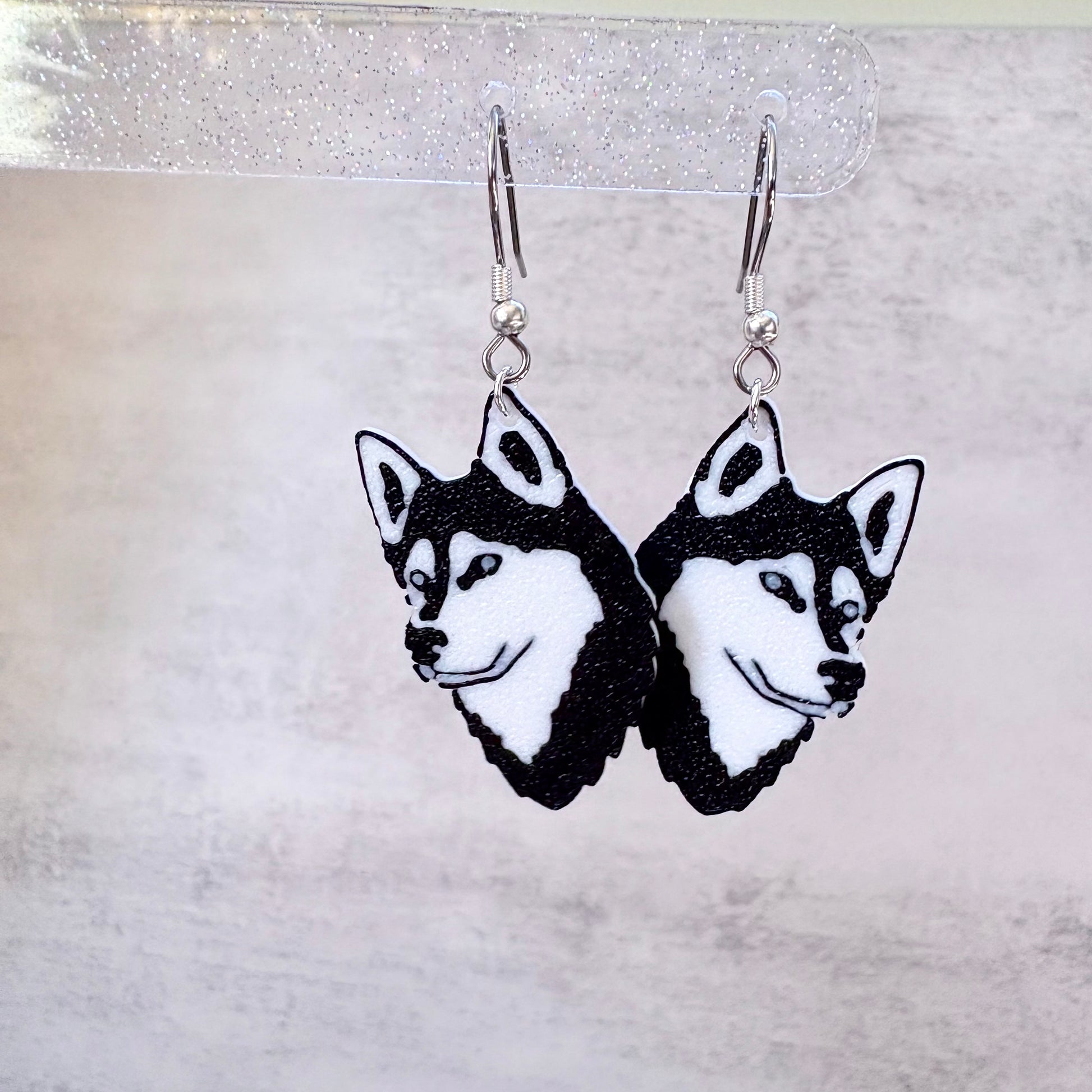 Siberian Husky dog face earrings on a gray background