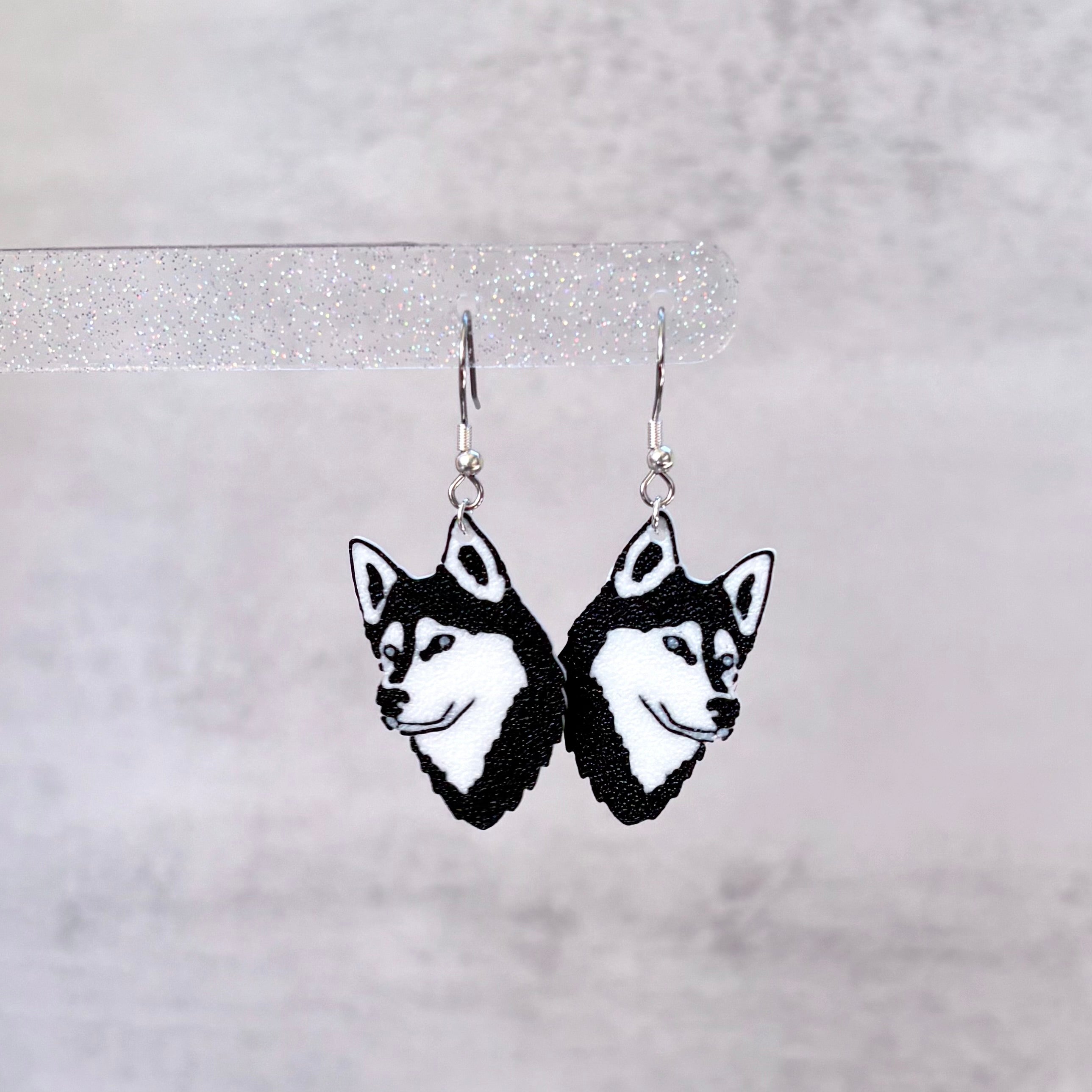 Siberian Husky dog face earrings on a gray background