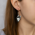Person wearing dog-shaped earrings with a plain background