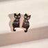 Black cat earrings with Christmas lights on a beige background