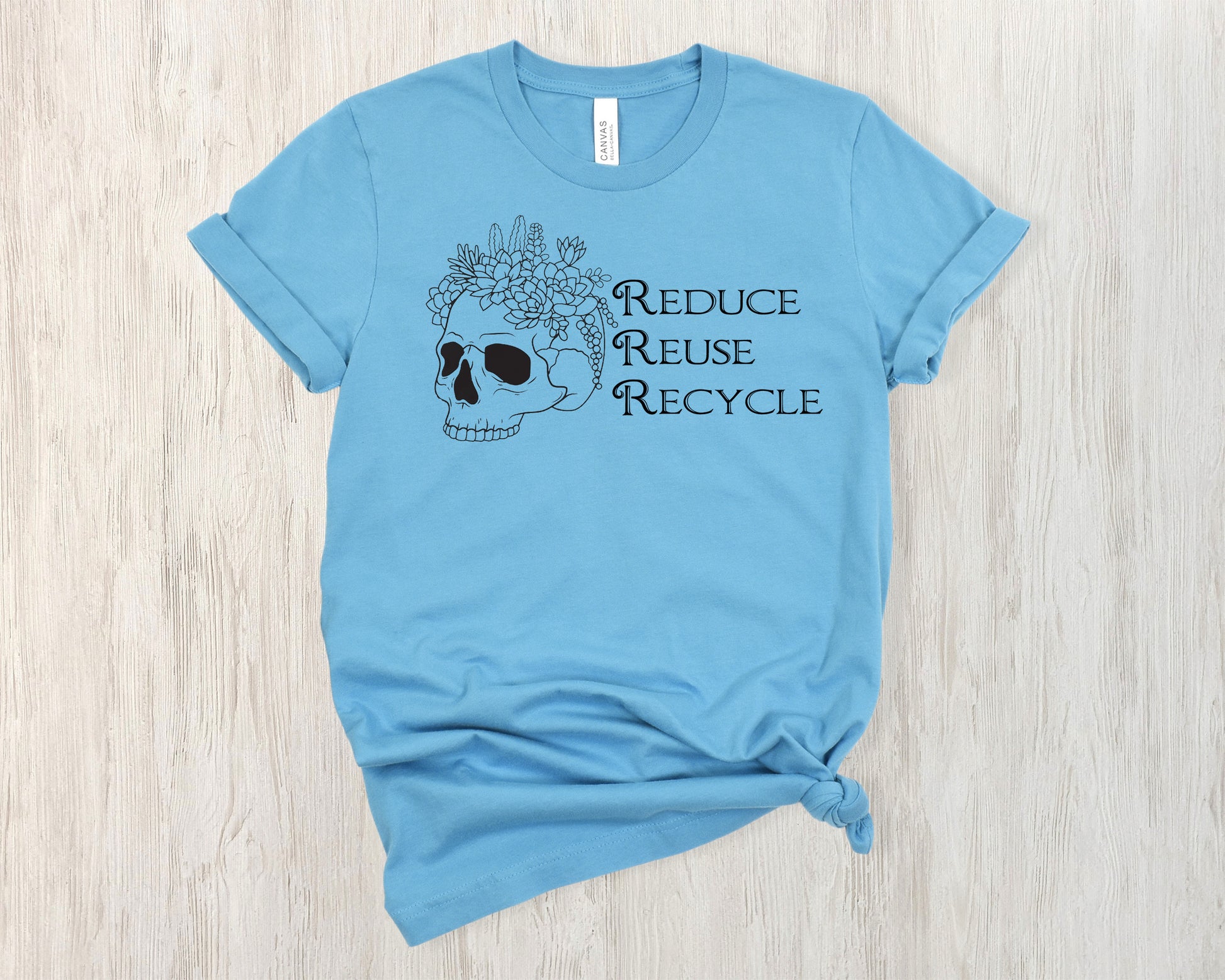 Sage green t-shirt with skull and flowers design and 'Reduce Reuse Recycle' text 