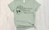 Sage green t-shirt with skull and flowers design and 'Reduce Reuse Recycle' text 