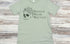 Sage green t-shirt with skull and flowers design and 'Reduce Reuse Recycle' text 