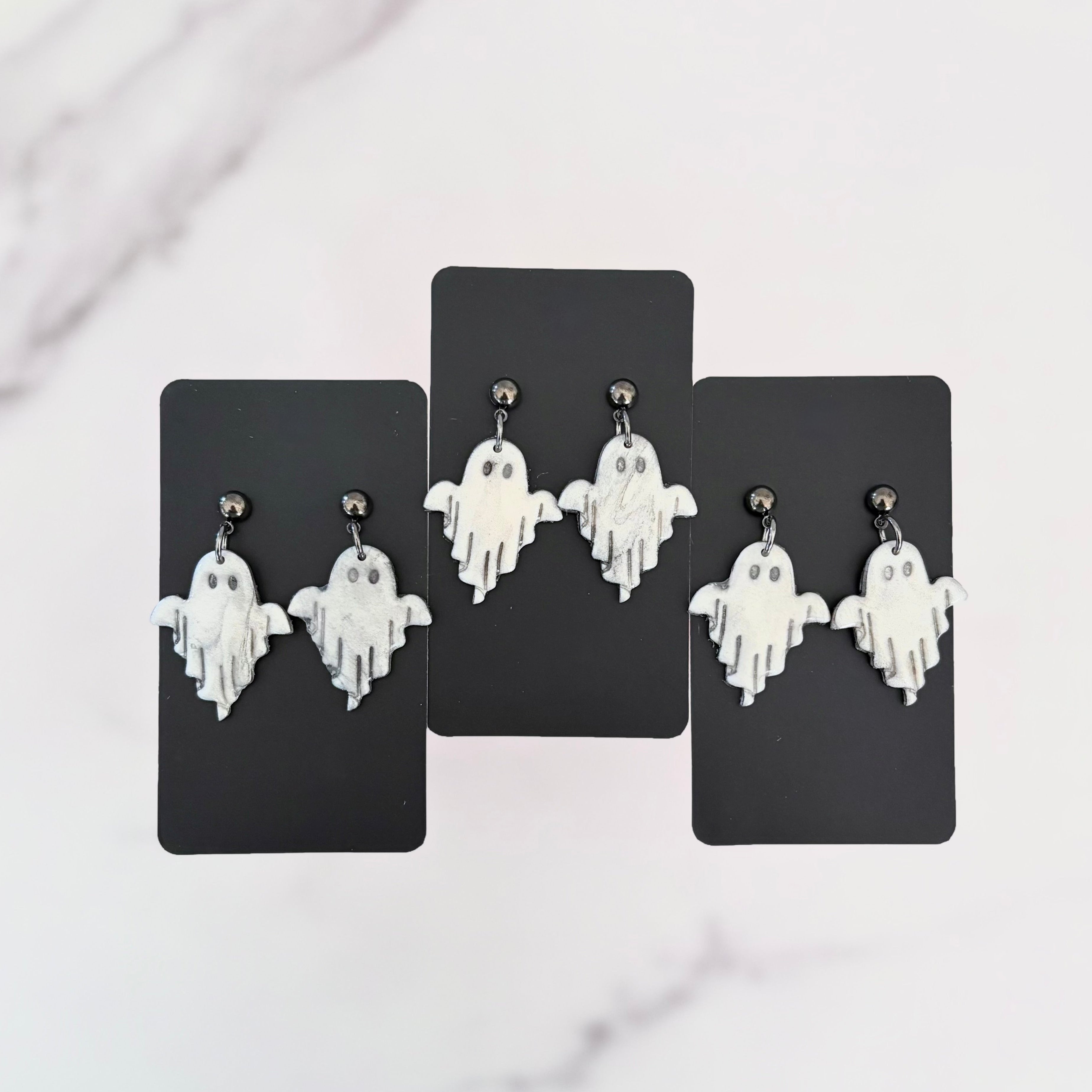 Glossy dangling ghost earrings with marble vein effect