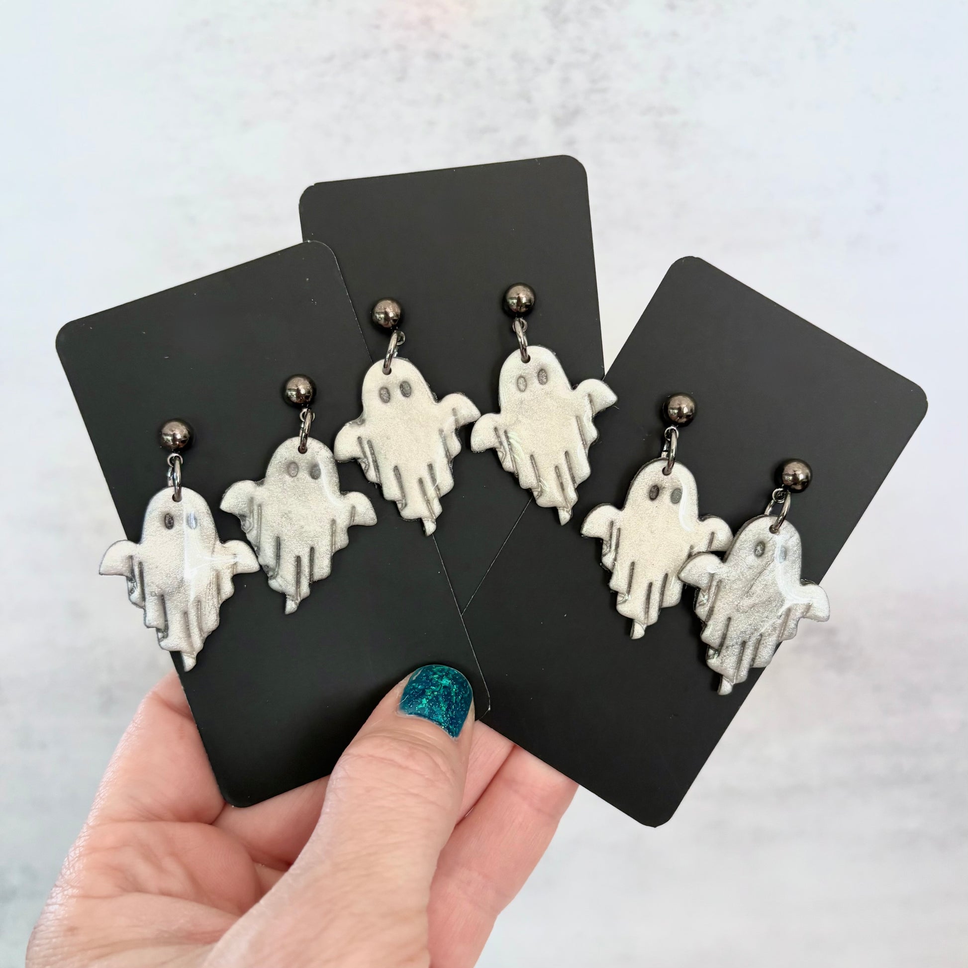 Glossy dangling ghost earrings with marble vein effect